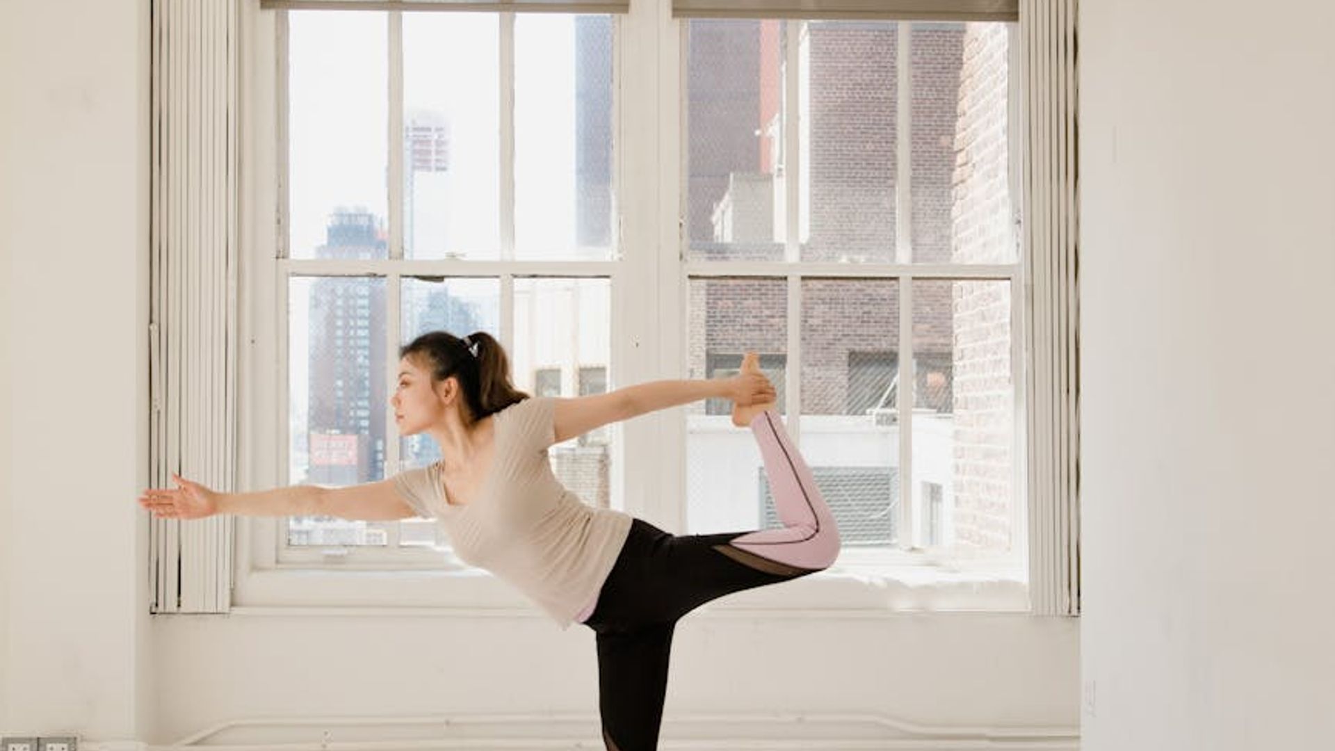 Person doing a peaceful yoga stretch in a bright studio.