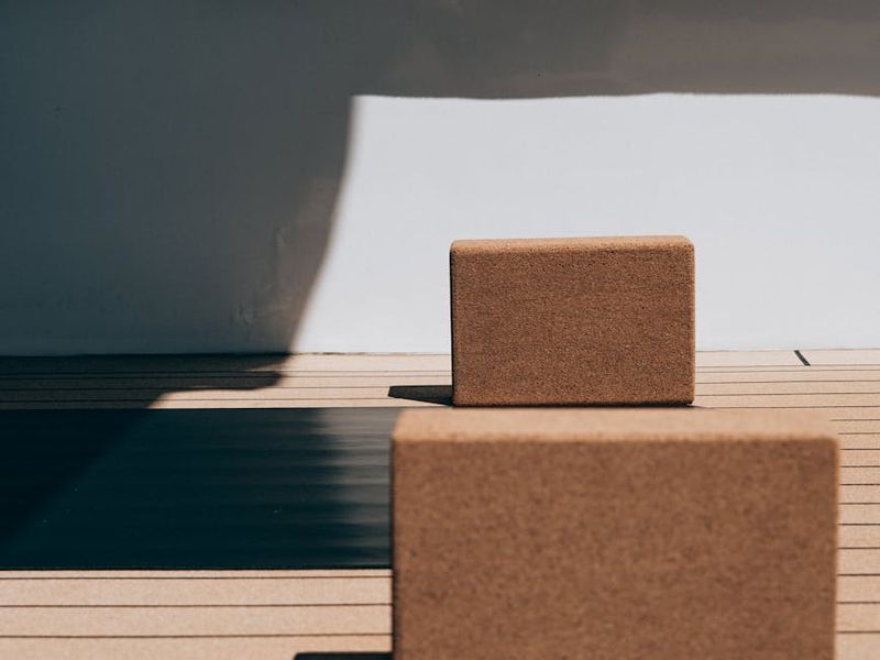 Yoga mat and blocks on a clean wooden floor.